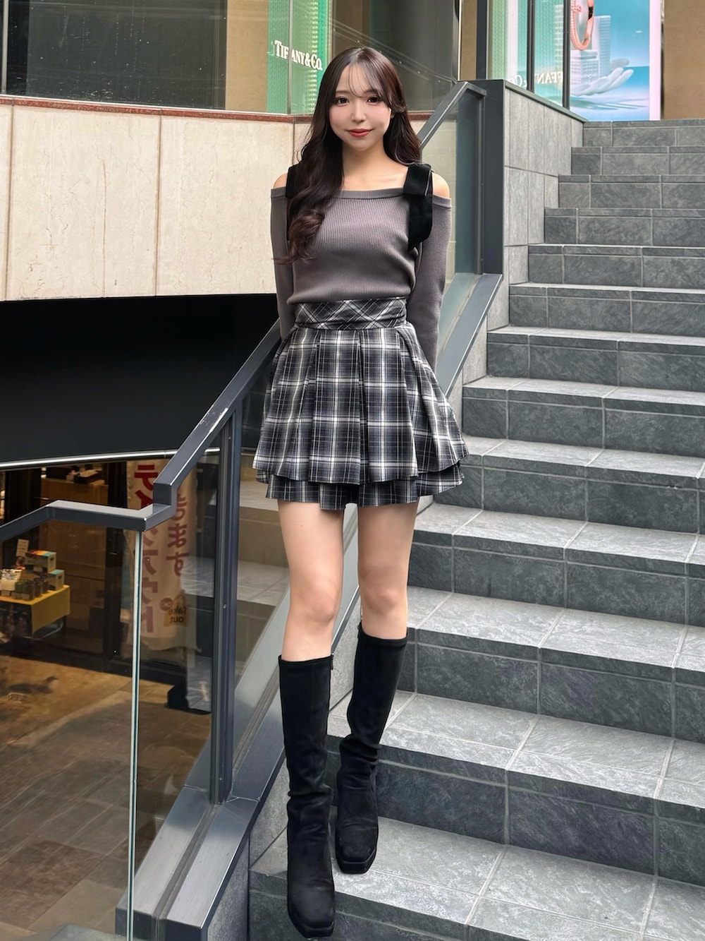 グレー系のニット/セーター、ブラック系のスカートを着用したレディースの秋コーディネートの2枚目の写真