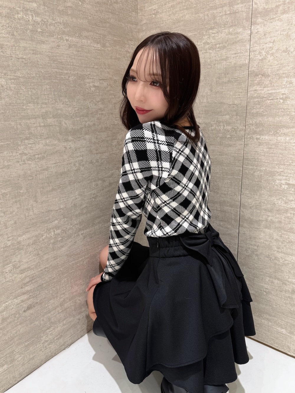 ブラック系のスカート、ブラック系のニット/セーターを着用したレディースの秋コーディネートの3枚目の写真