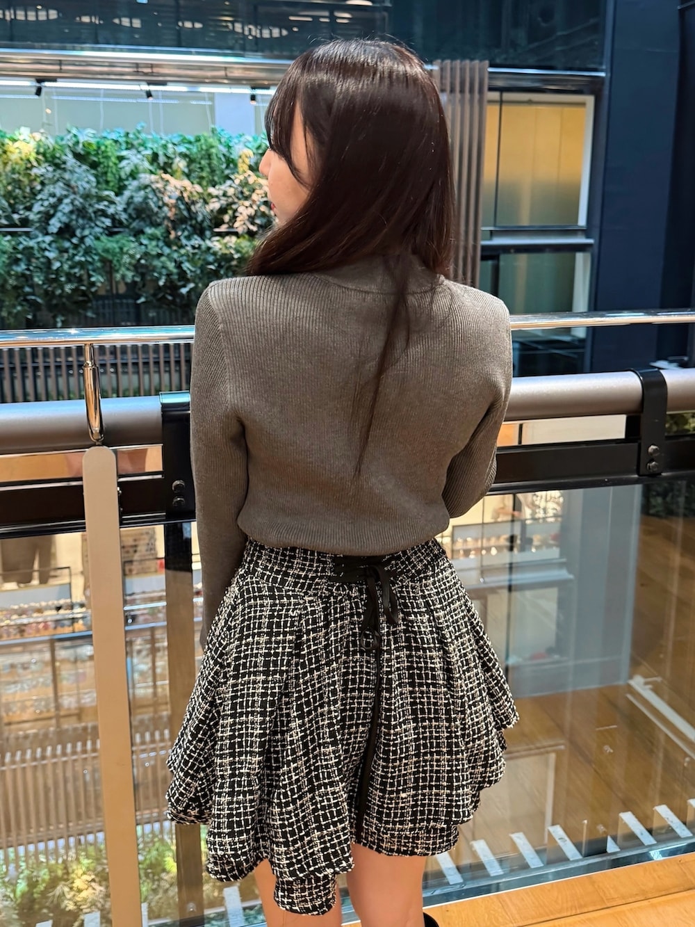 ホワイト系のトートバッグ、ブラック系のブーツ、ブラック系のスカートを着用したレディースの秋コーディネートの4枚目の写真