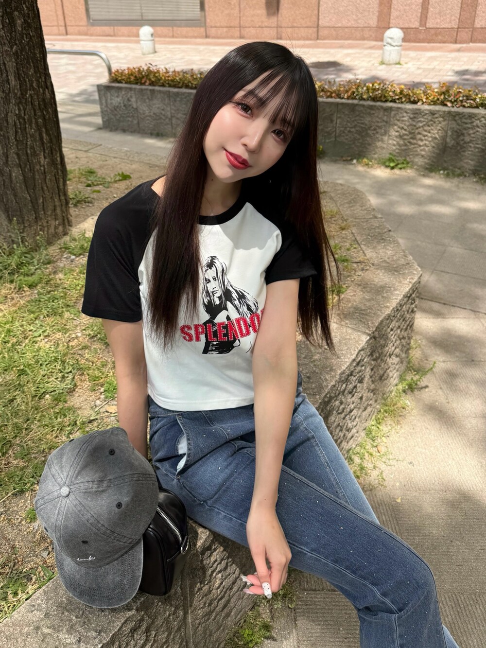 ホワイト系のTシャツ/カットソー、ブラック系のハンドバッグ、ブルー系のデニムパンツを着用したレディースの春コーディネートの2枚目の写真