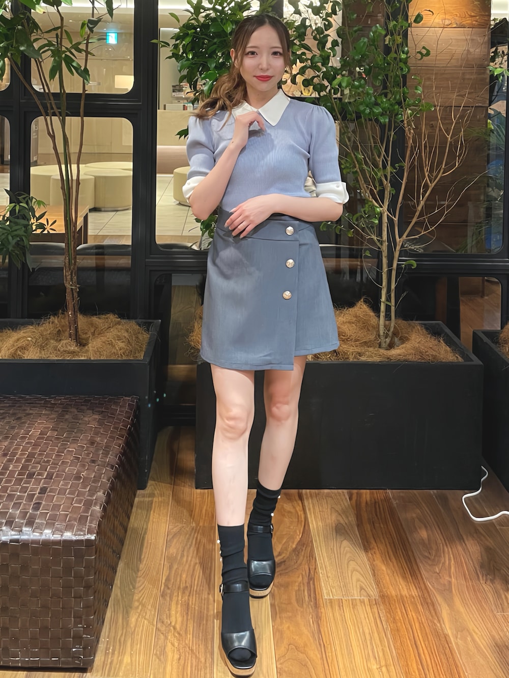 ブルー系のニット/セーター、グレー系のスカート、ブラック系のサンダルを着用したレディースの夏コーディネートの3枚目の写真