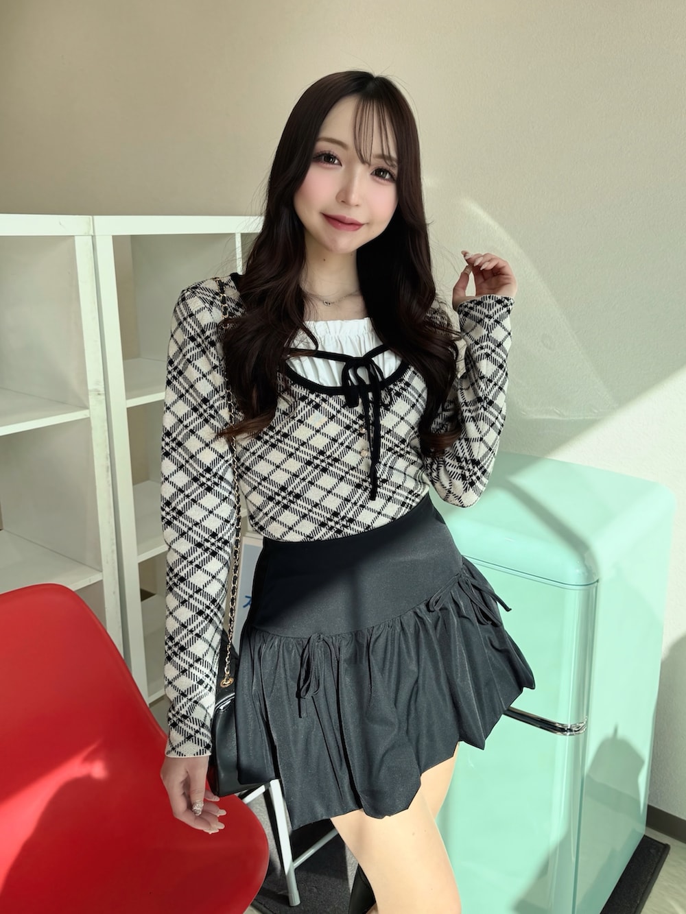 ベージュ系のニット/セーター、ブラック系のショルダーバッグ、ブラック系のスカートを着用したレディースの春コーディネートの4枚目の写真