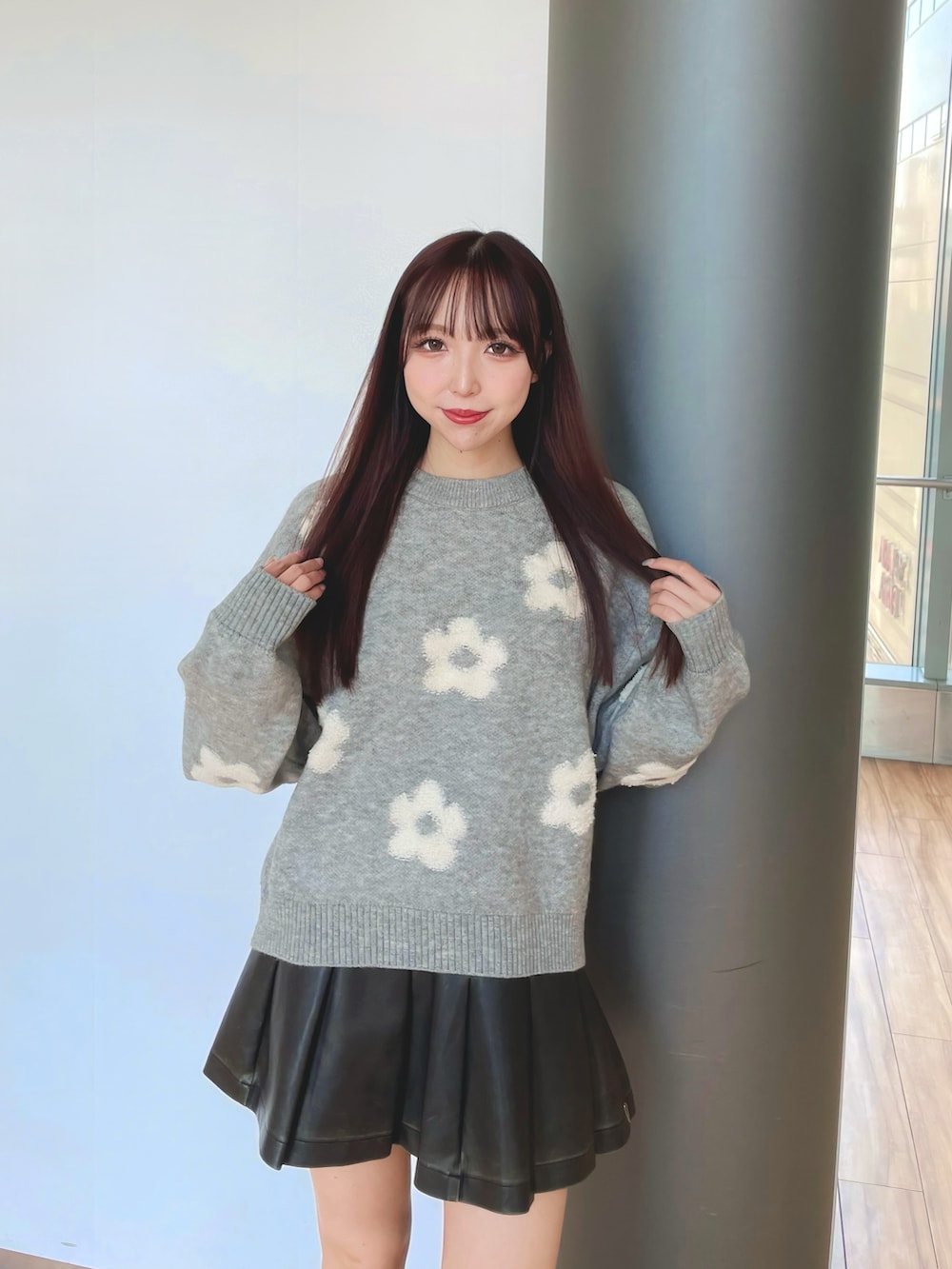 グレー系のニット/セーター、ブラック系のスカートを着用したレディースの冬コーディネートの2枚目の写真