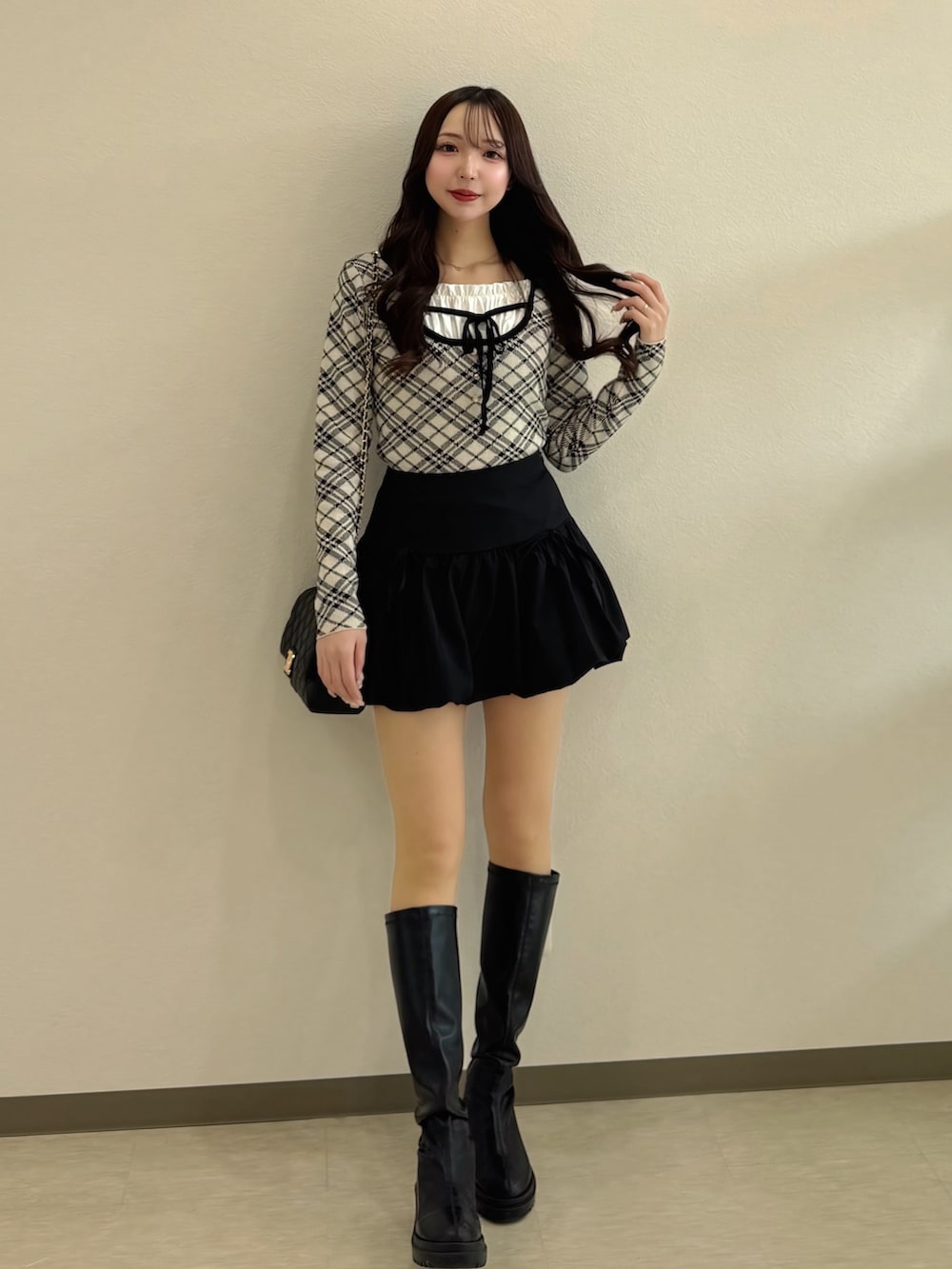 ベージュ系のニット/セーター、ブラック系のショルダーバッグ、ブラック系のスカートを着用したレディースの春コーディネートの3枚目の写真