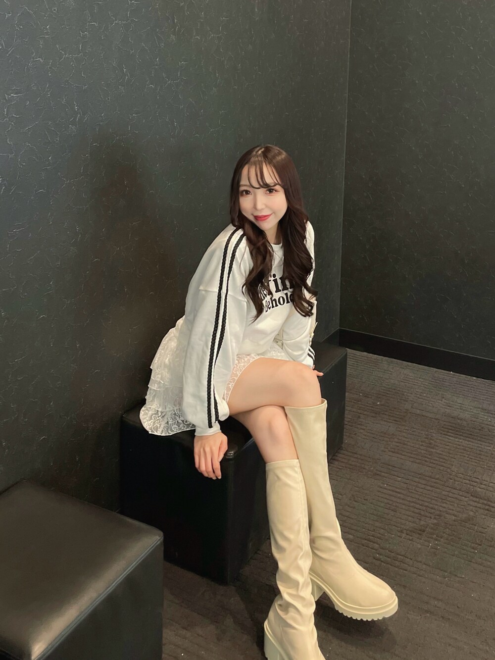 ホワイト系のスウェット、ホワイト系のスカート、ホワイト系のハンドバッグを着用したレディースの春コーディネートの2枚目の写真