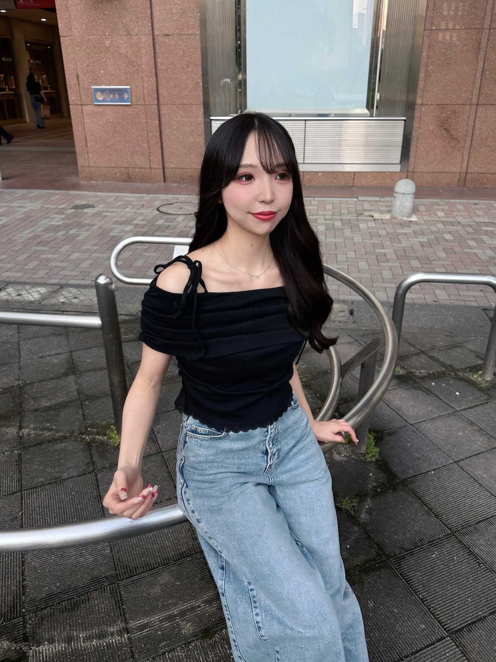 ブルー系のデニムパンツ、ブラック系のTシャツ/カットソー、ホワイト系のサンダルを着用したレディースの夏コーディネートの4枚目の写真