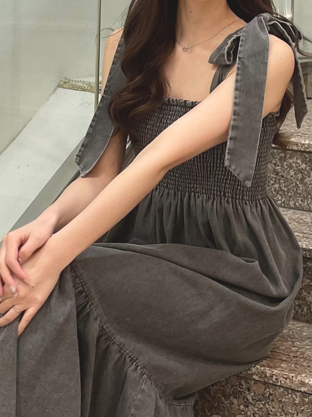 グレー系のワンピース、ブラック系のサンダルを着用したレディースの夏コーディネートの3枚目の写真