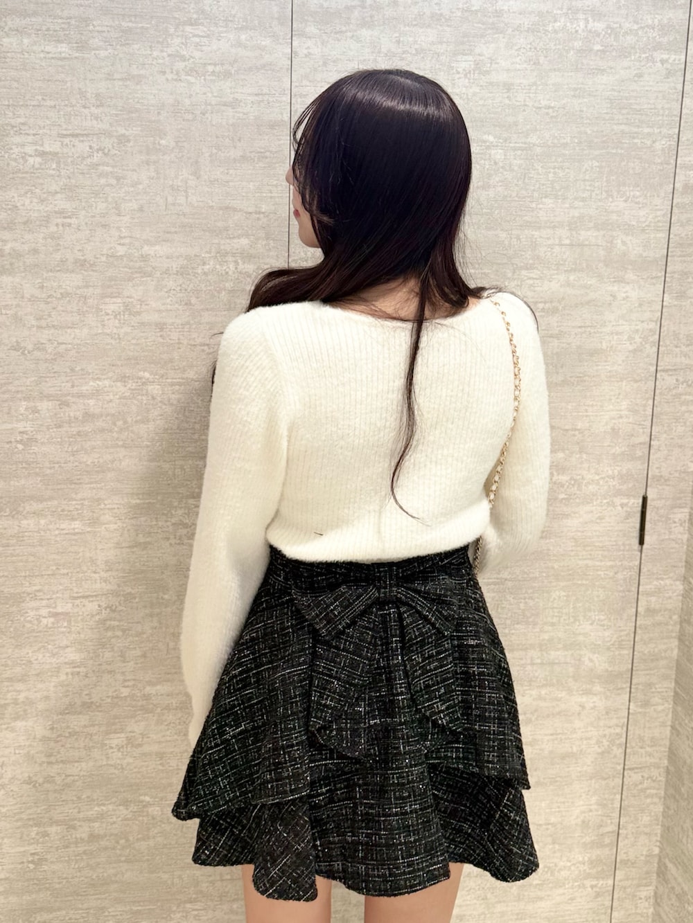 ホワイト系のニット/セーター、ブラック系のスカート、ホワイト系のショルダーバッグを着用したレディースの秋コーディネートの3枚目の写真