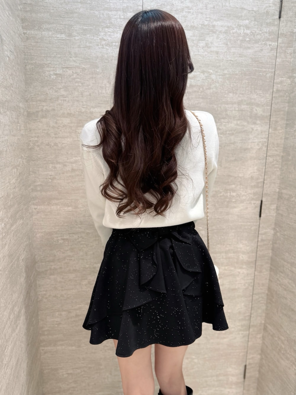 ホワイト系のカーディガン/ボレロ、ブラック系のスカート、ホワイト系のショルダーバッグを着用したレディースの春コーディネートの5枚目の写真