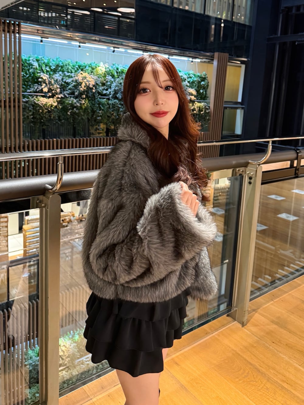 グレー系のブルゾン、ブラック系のスカートを着用したレディースの冬コーディネートの5枚目の写真