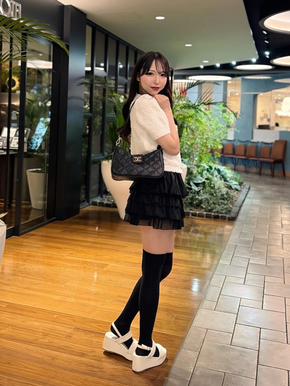 ホワイト系のカーディガン/ボレロ、ブラック系のスカート、ホワイト系のサンダルを着用したレディースの夏コーディネートの3枚目の写真