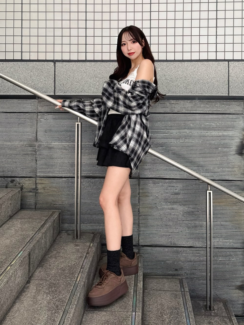 ブラック系のシャツ/ブラウス、ブラック系のスカート、ブラウン系のスニーカーを着用したレディースの秋コーディネートの3枚目の写真