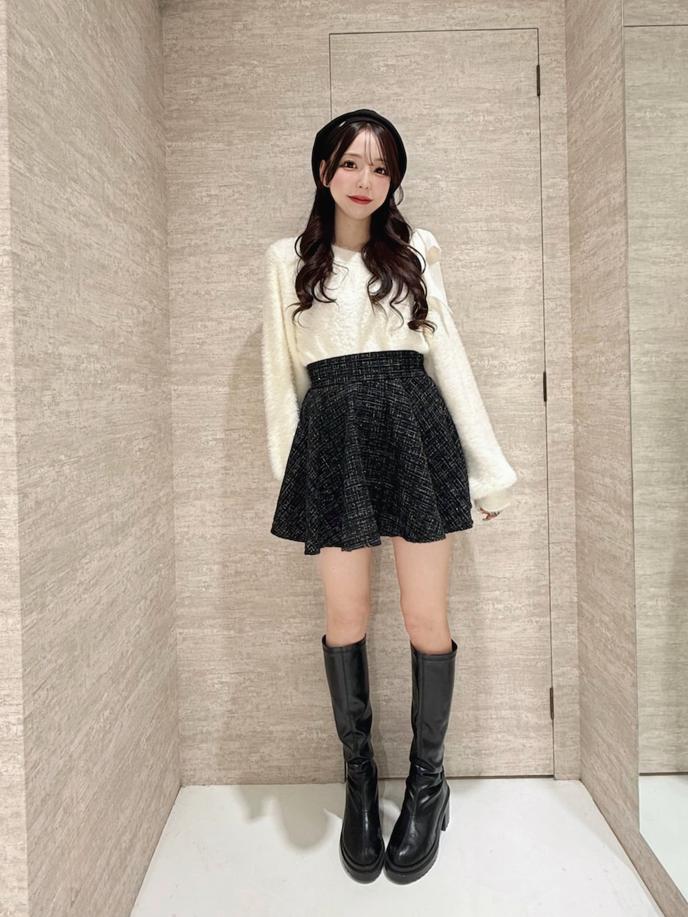 ホワイト系のニット/セーター、ブラック系のスカート、ブラック系のハンチング/ベレー帽を着用したレディースの秋コーディネートの3枚目の写真