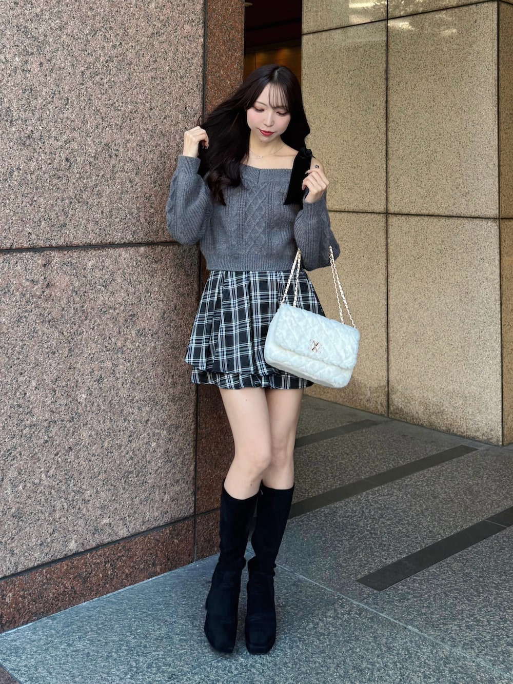 グレー系のニット/セーター、ホワイト系のショルダーバッグ、ブラック系のスカートを着用したレディースの秋コーディネートの2枚目の写真