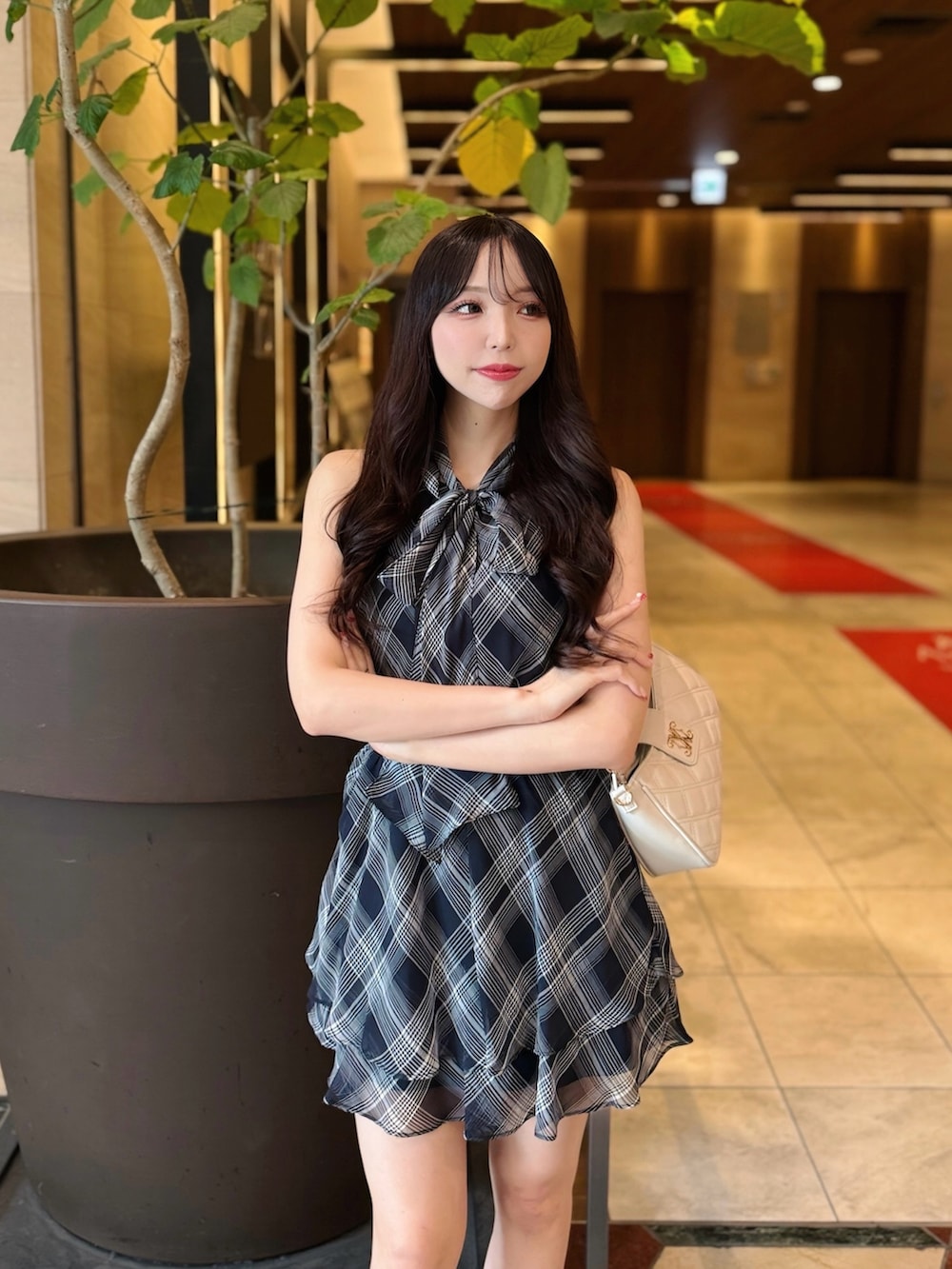 ブラック系のワンピース、ホワイト系のショルダーバッグ、ブラック系のサンダルを着用したレディースの夏コーディネートの6枚目の写真