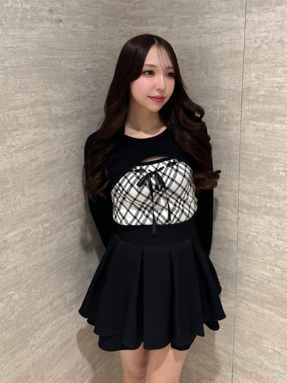 ホワイト系のニット/セーター、ブラック系のスカートを着用したレディースの冬コーディネートの2枚目の写真