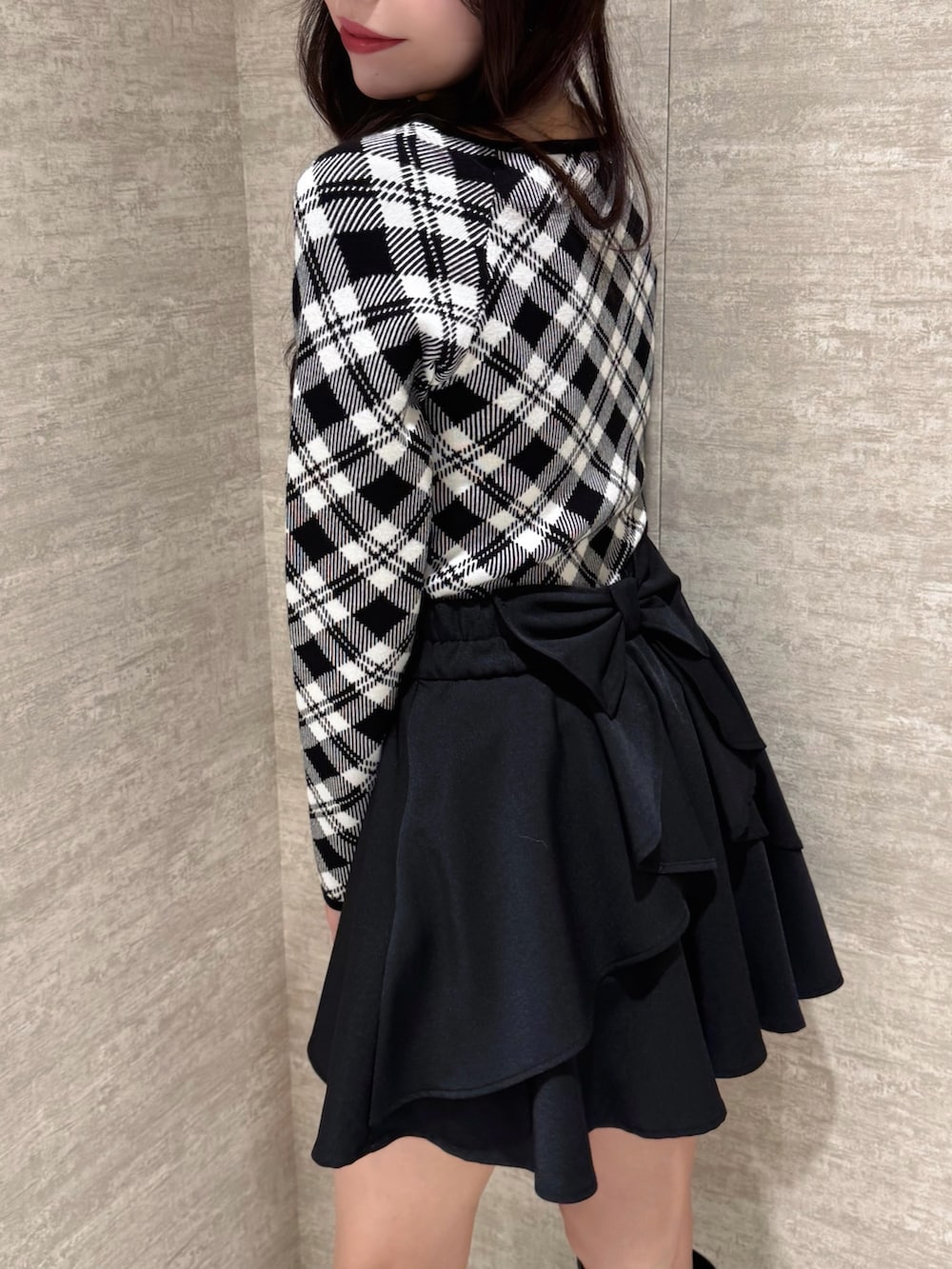 ブラック系のスカート、ブラック系のニット/セーターを着用したレディースの秋コーディネートの2枚目の写真