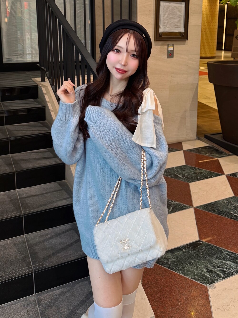 ブルー系のチュニック、ベージュ系のブーツ、ホワイト系のショルダーバッグを着用したレディースの冬コーディネートの7枚目の写真