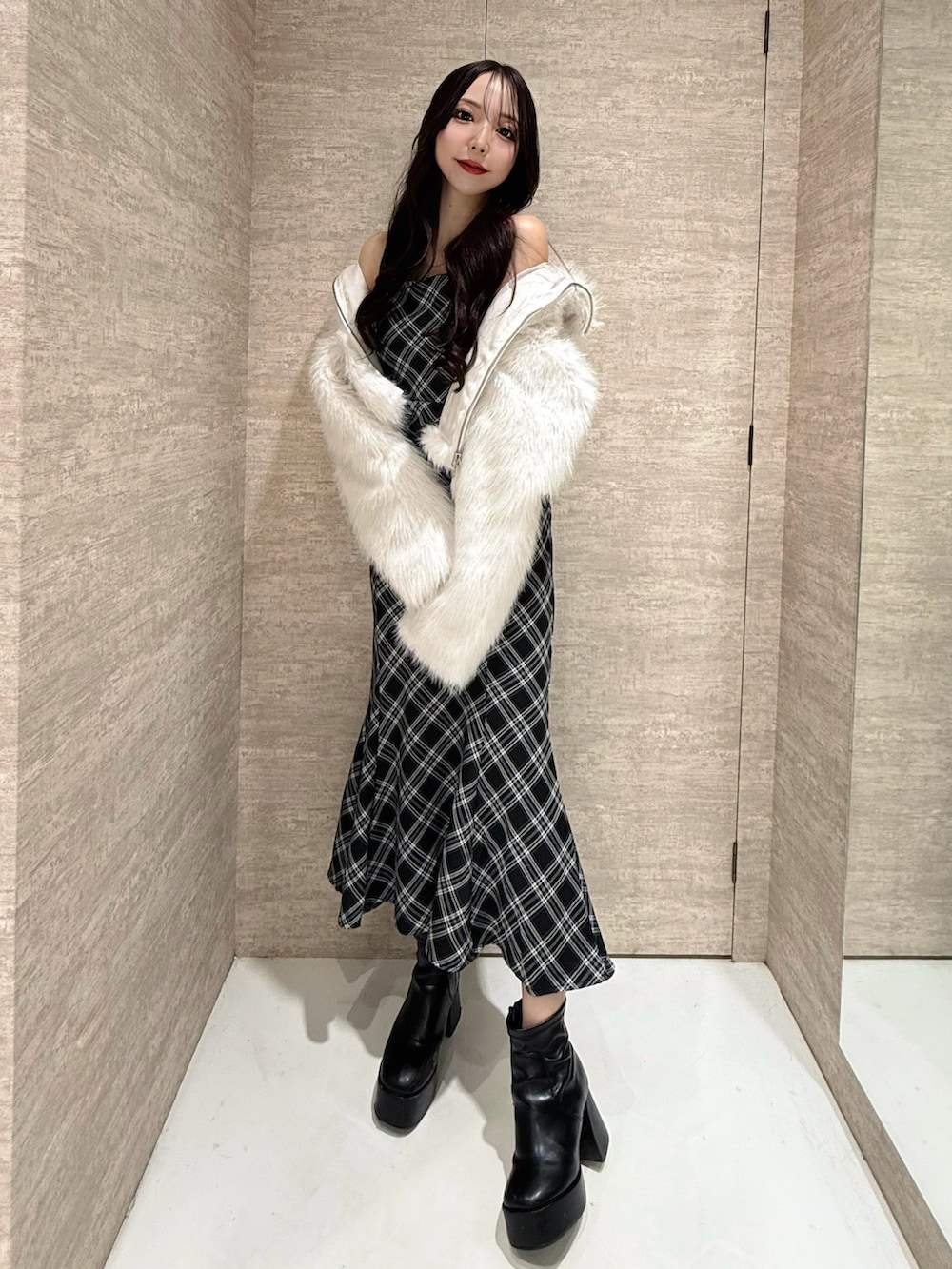 ホワイト系のブルゾン、ブラック系のワンピース、ブラック系のショルダーバッグを着用したレディースの秋コーディネートの3枚目の写真