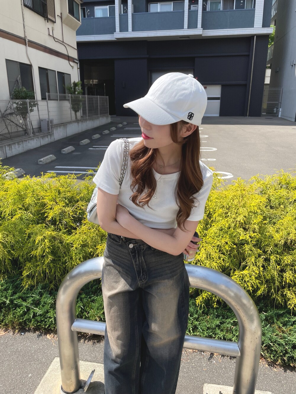 ブルー系のデニムパンツ、ホワイト系のTシャツ/カットソー、シルバー系のショルダーバッグを着用したレディースの夏コーディネートの4枚目の写真