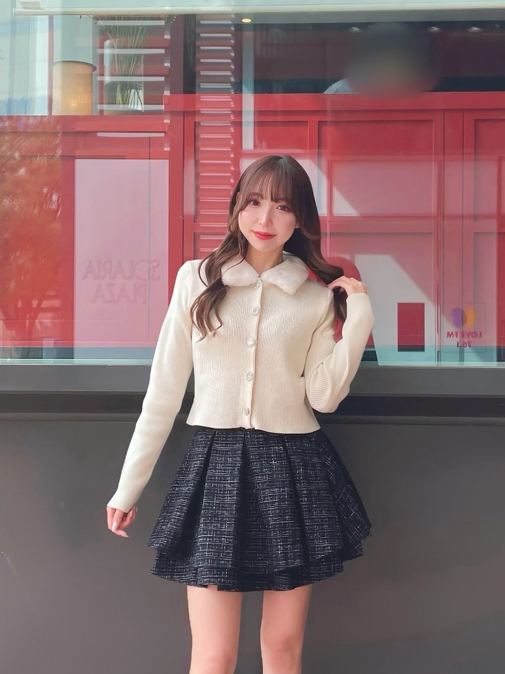 ホワイト系のカーディガン/ボレロ、ブラック系のスカートを着用したレディースの秋コーディネートの2枚目の写真