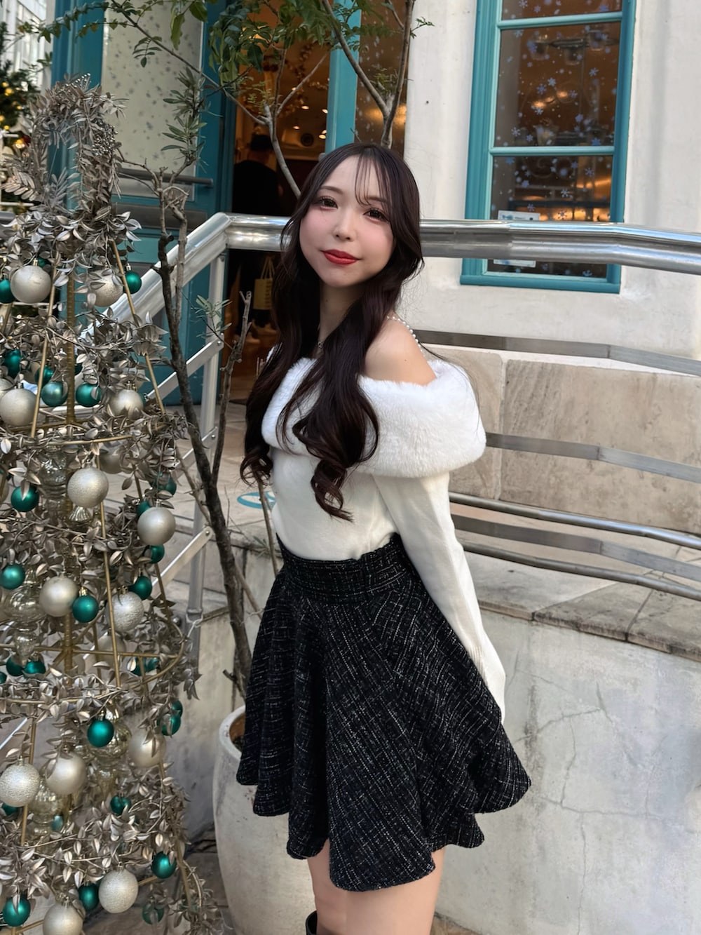 ブラック系のブーツ、ブラック系のショルダーバッグ、ブラック系のスカートを着用したレディースの秋コーディネートの7枚目の写真