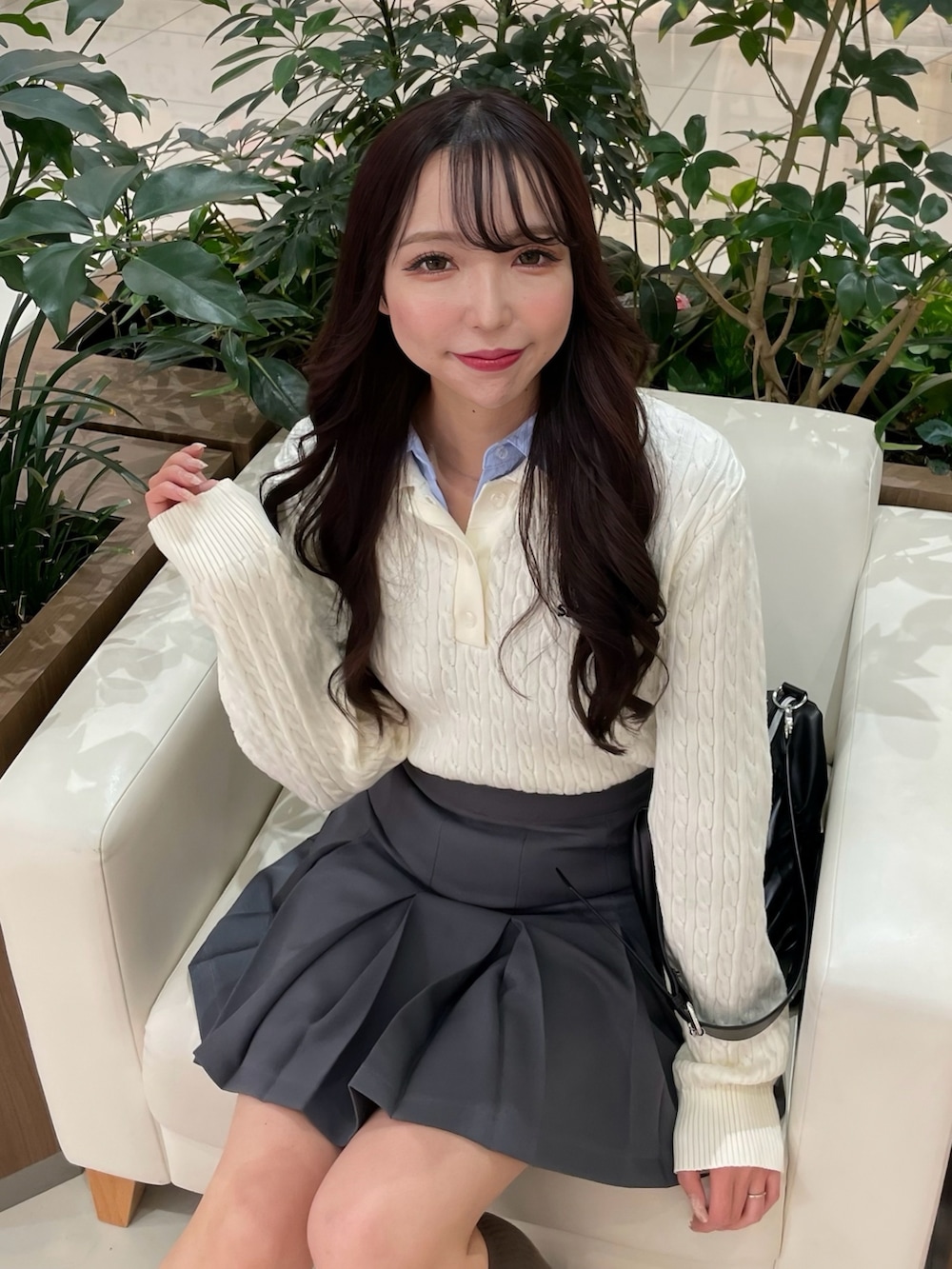 ホワイト系のニット/セーター、グレー系のスカート、ブラック系のローファーを着用したレディースの春コーディネートの2枚目の写真