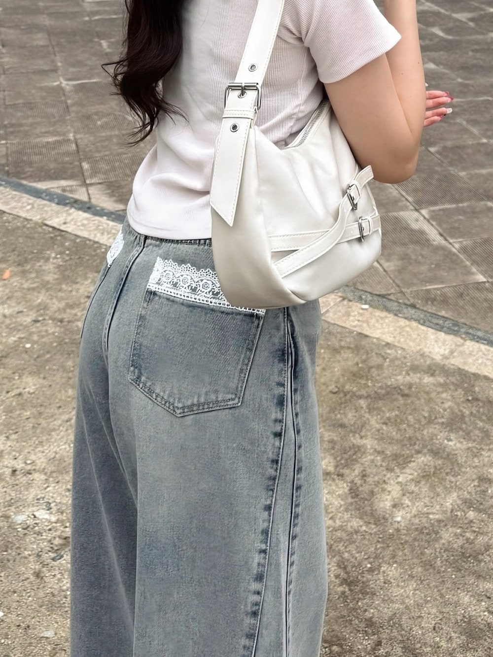 ブルー系のデニムパンツ、ピンク系のTシャツ/カットソー、ホワイト系のハンドバッグを着用したレディースの夏コーディネートの5枚目の写真