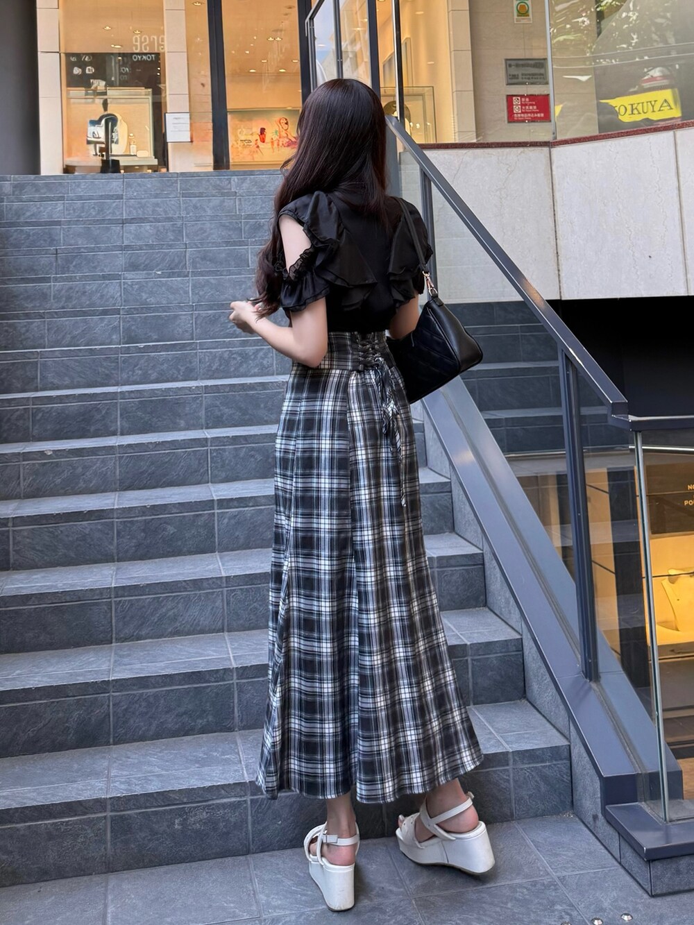 ブラック系のワンピース、ホワイト系のサンダル、ブラック系のショルダーバッグを着用したレディースの夏コーディネートの3枚目の写真