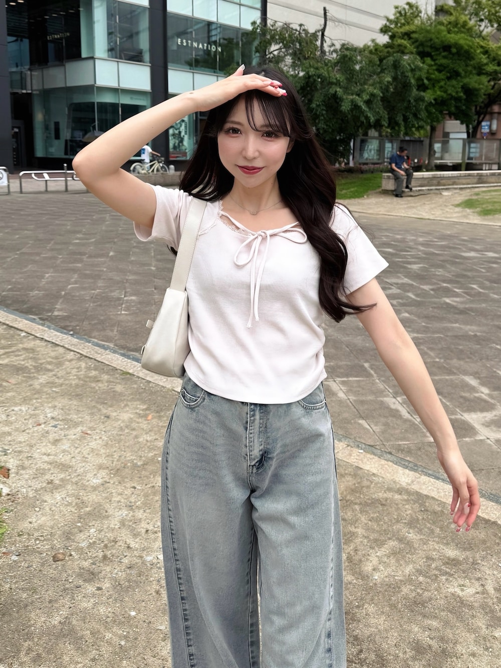 ブルー系のデニムパンツ、ピンク系のTシャツ/カットソー、ホワイト系のハンドバッグを着用したレディースの夏コーディネートの7枚目の写真