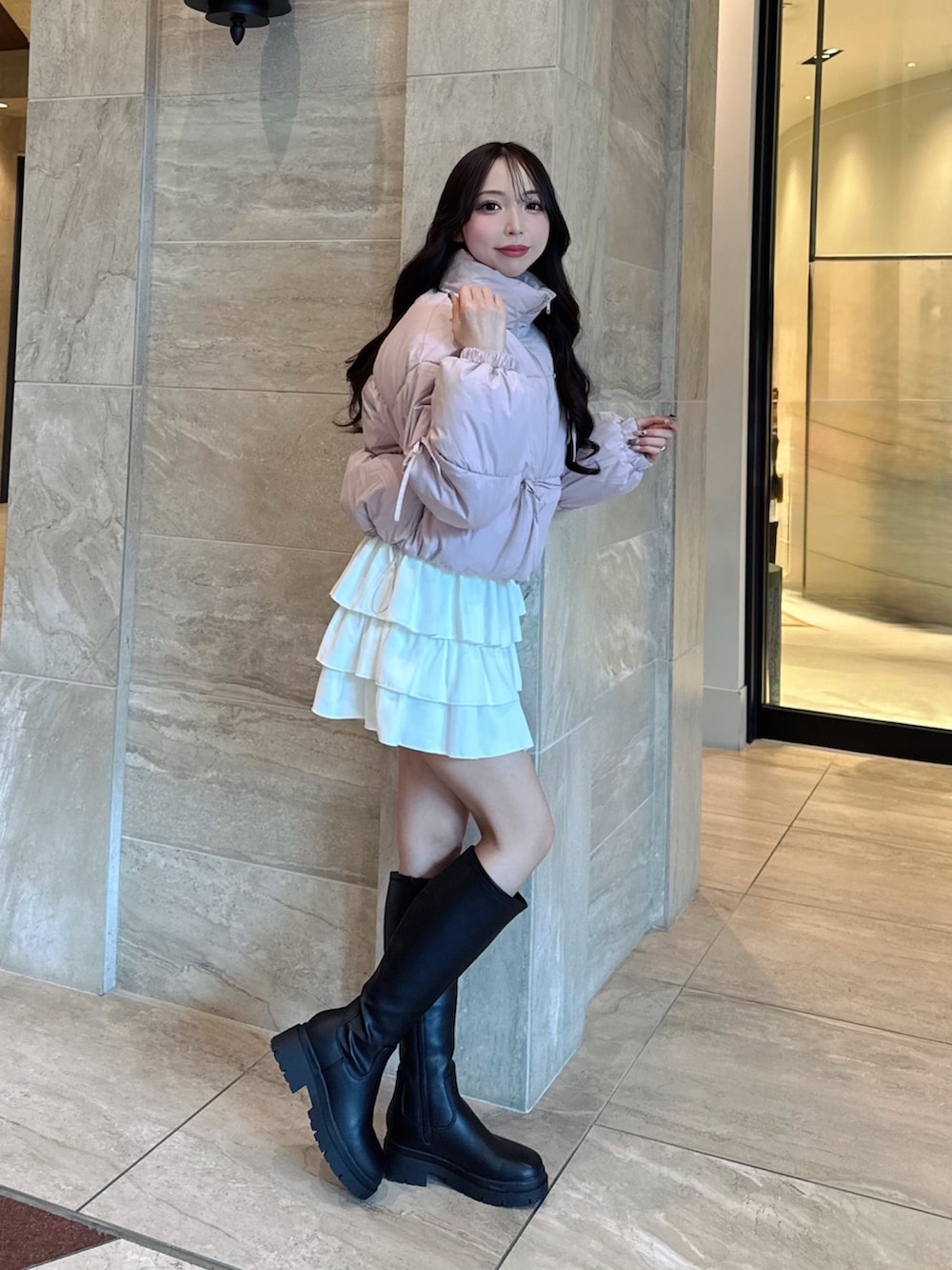 ピンク系のその他アウター、ホワイト系のスカート、ブラック系のブーツを着用したレディースの秋コーディネートの2枚目の写真