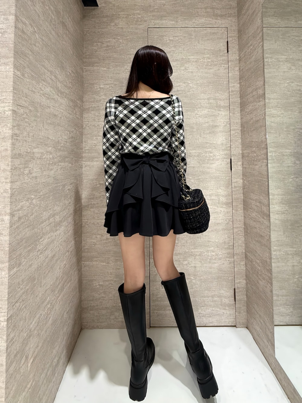 ブラック系のスカート、ブラック系のニット/セーターを着用したレディースの秋コーディネートの6枚目の写真