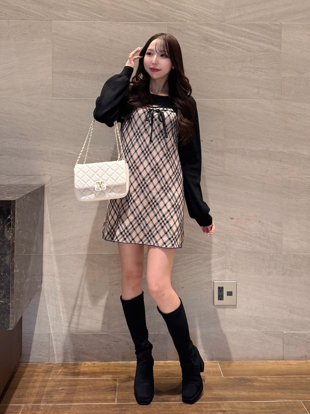 ベージュ系のワンピース、ホワイト系のショルダーバッグを着用したレディースの冬コーディネートの2枚目の写真