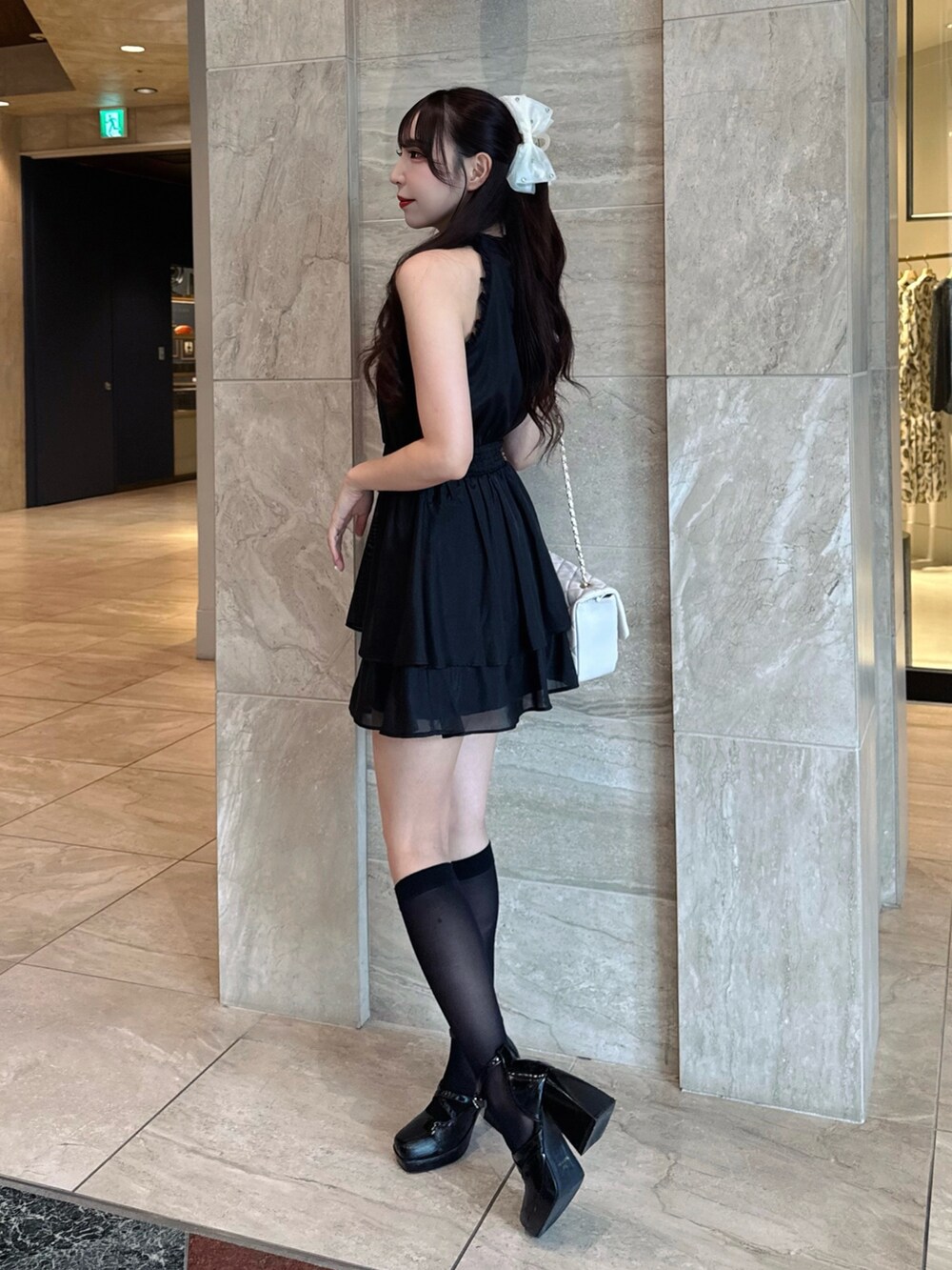 ブラック系のワンピース、ホワイト系のショルダーバッグを着用したレディースの夏コーディネートの2枚目の写真