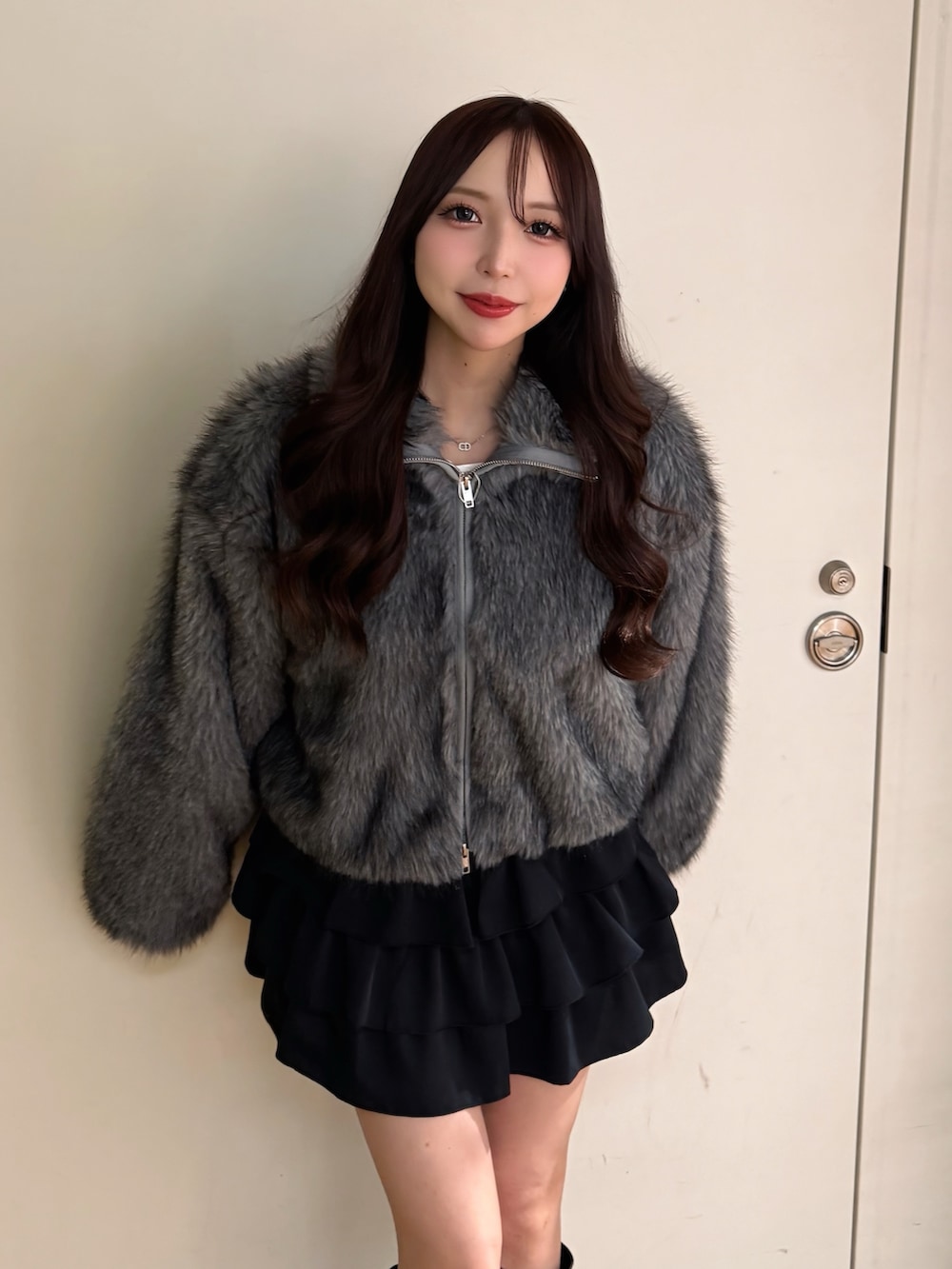 グレー系のブルゾン、ブラック系のスカートを着用したレディースの冬コーディネートの3枚目の写真