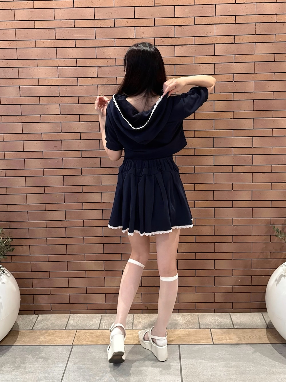 ブルー系のスカート、ブルー系のパーカー、ホワイト系のサンダルを着用したレディースの夏コーディネートの3枚目の写真