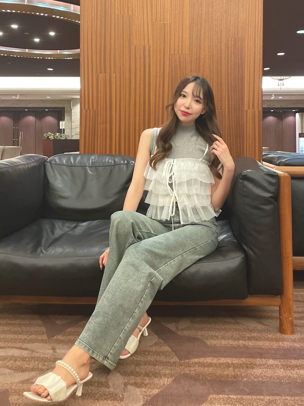ブルー系のデニムパンツ、ホワイト系のTシャツ/カットソー、グレー系のニット/セーターを着用したレディースの夏コーディネートの2枚目の写真
