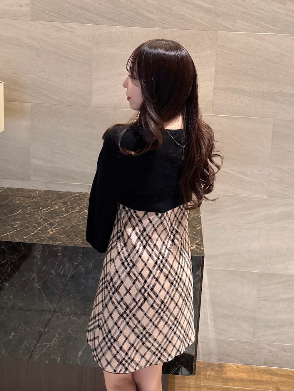 ベージュ系のワンピース、ホワイト系のショルダーバッグを着用したレディースの冬コーディネートの5枚目の写真