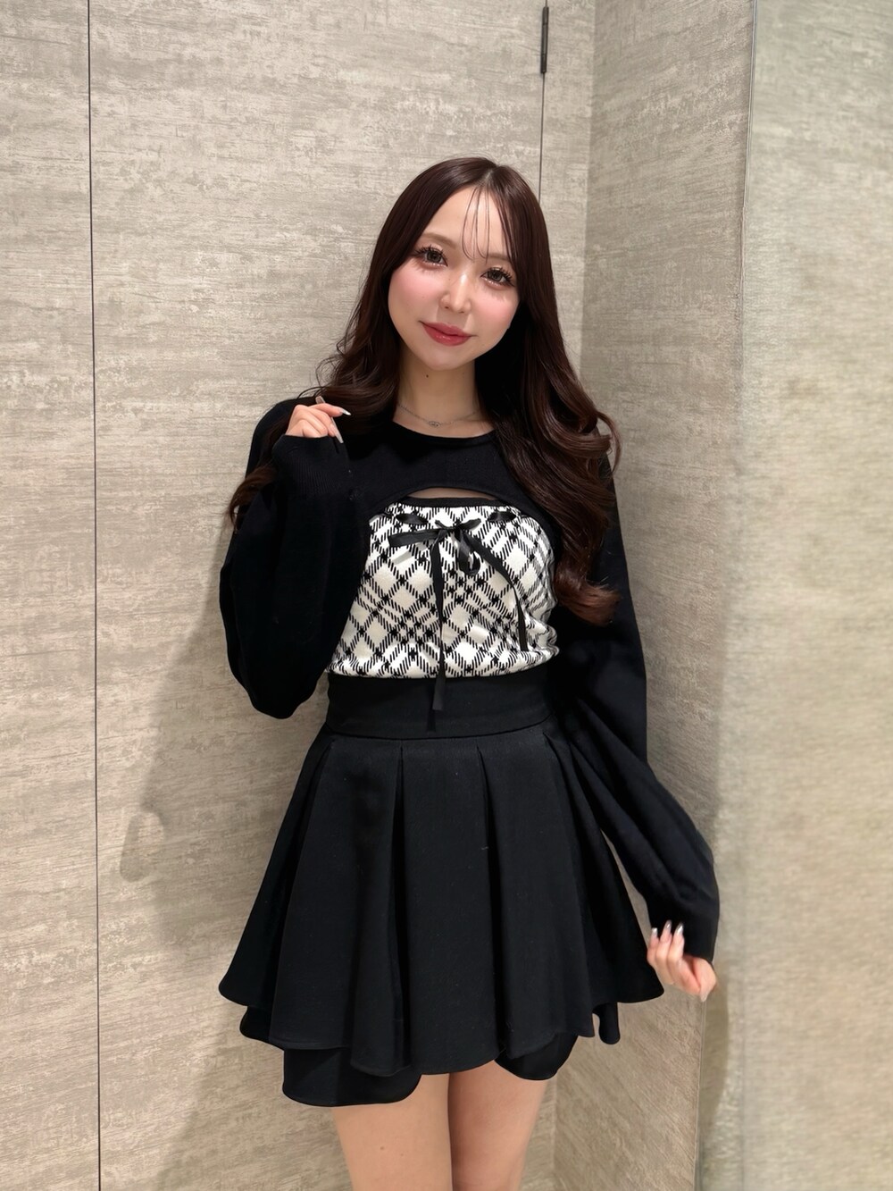 ホワイト系のニット/セーター、ブラック系のスカートを着用したレディースの冬コーディネートの3枚目の写真