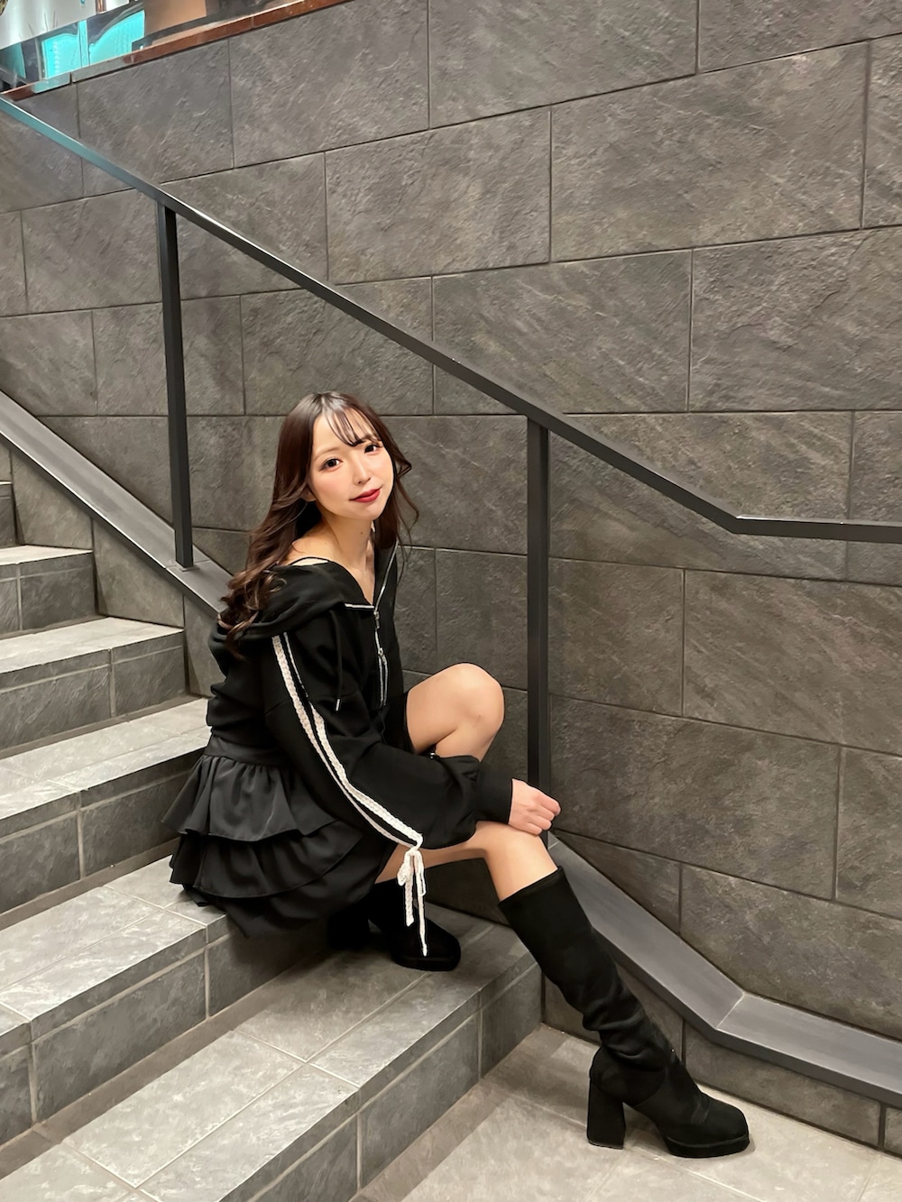 ブラック系のパーカー、ブラック系のキャミソール、ブラック系のスカートを着用したレディースの春コーディネートの4枚目の写真