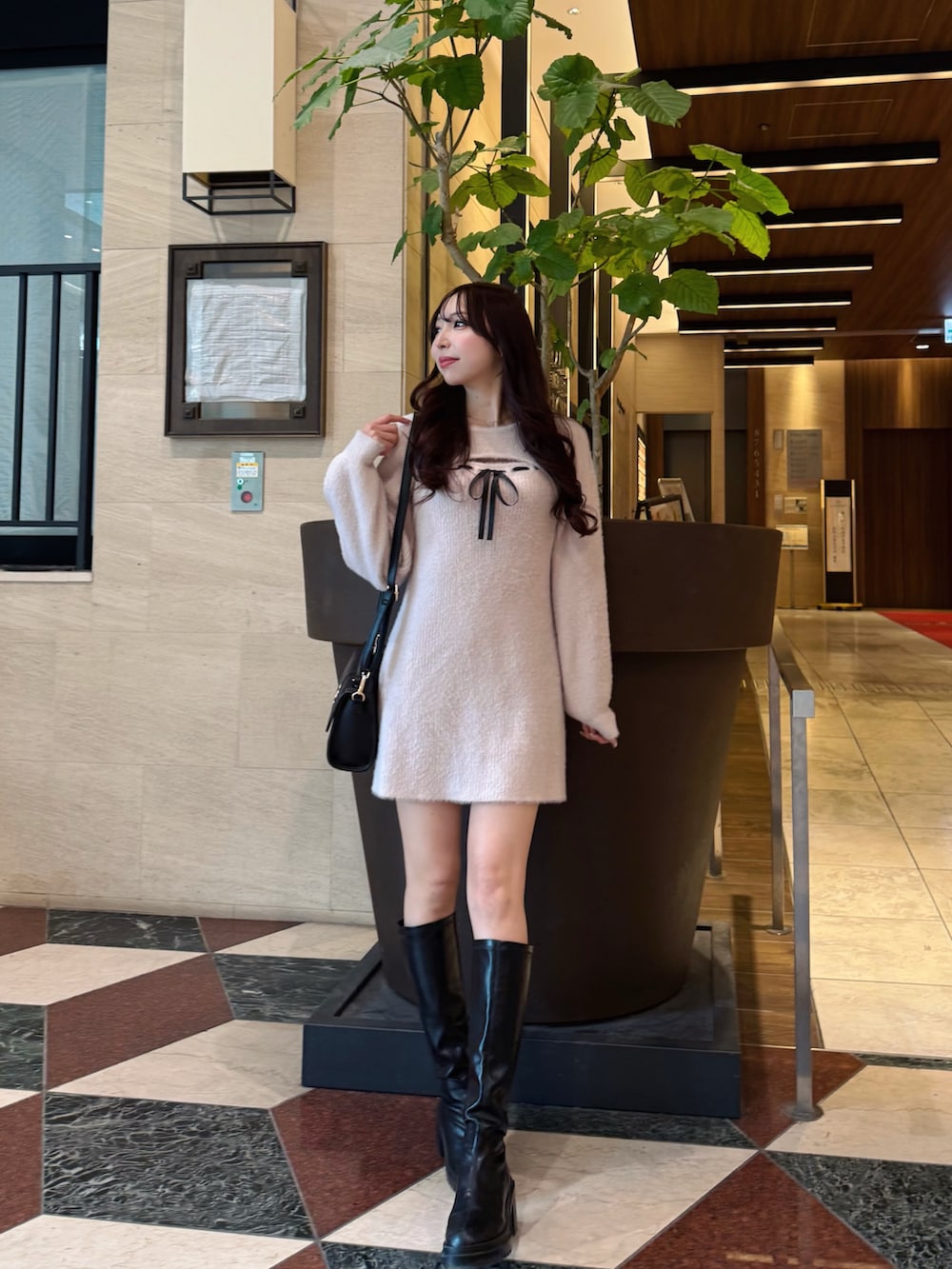 ピンク系のワンピース、ブラック系のハンドバッグを着用したレディースの冬コーディネートの2枚目の写真
