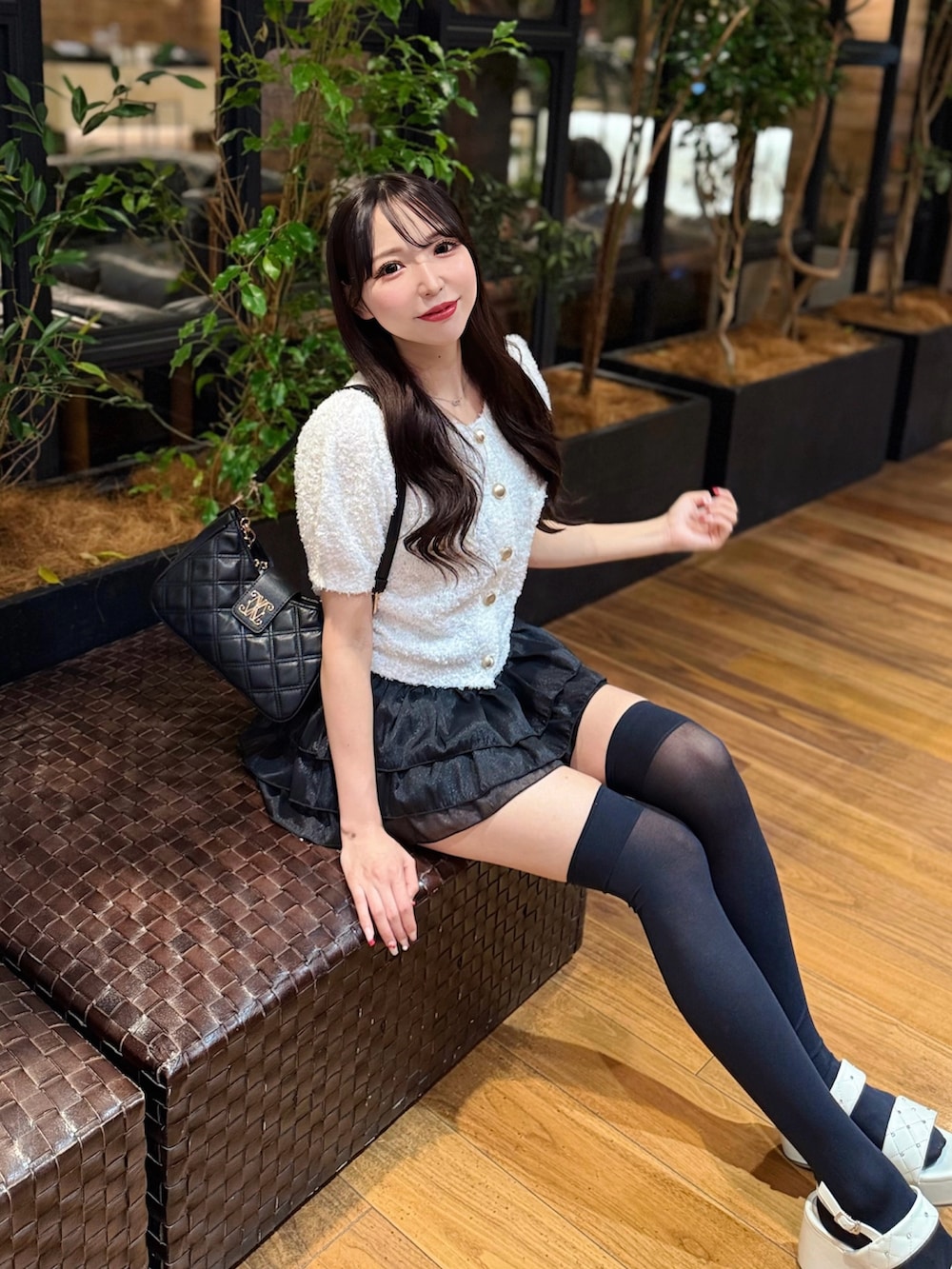 ホワイト系のカーディガン/ボレロ、ブラック系のスカート、ホワイト系のサンダルを着用したレディースの夏コーディネートの5枚目の写真