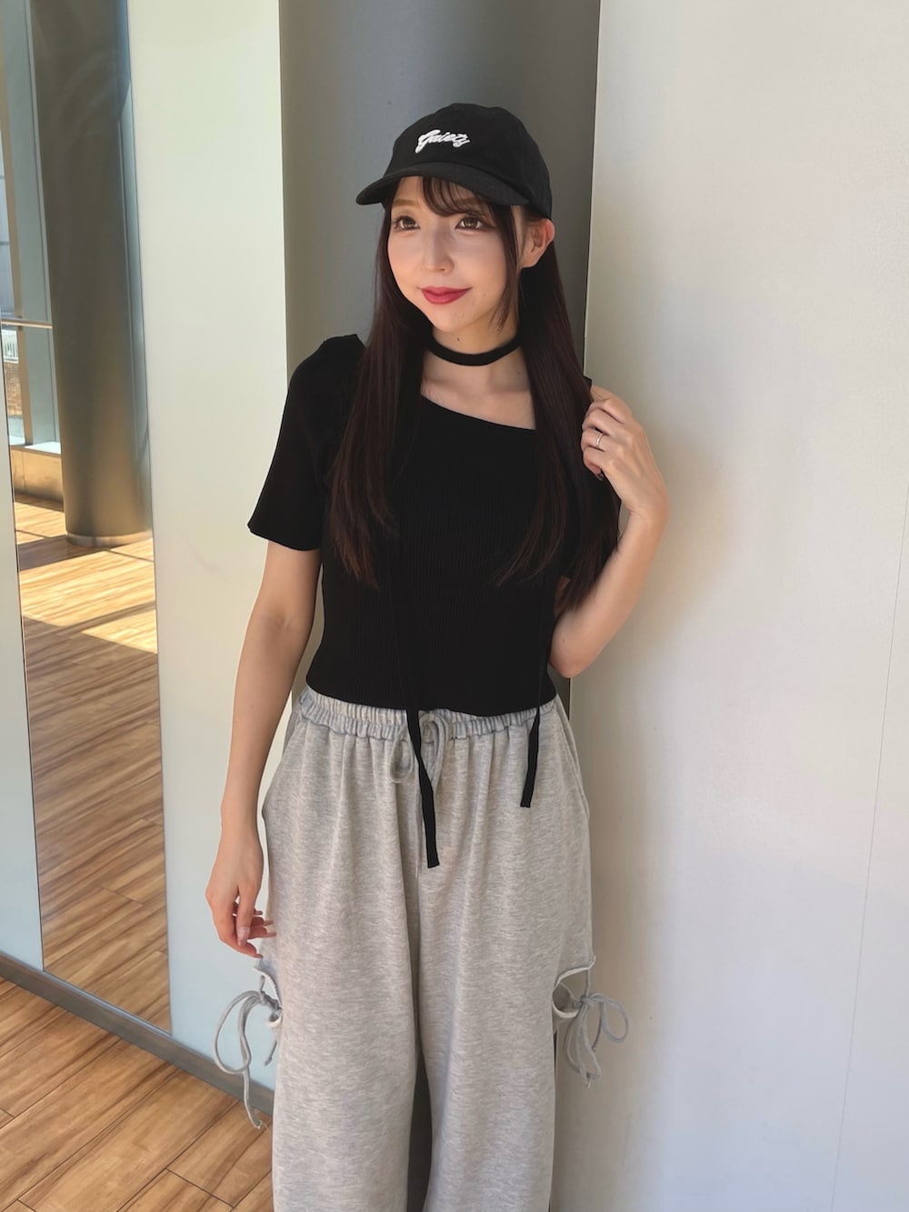 グレー系のスウェットパンツ、ブルー系のニット/セーター、ブラック系のキャップを着用したレディースの夏コーディネートの2枚目の写真