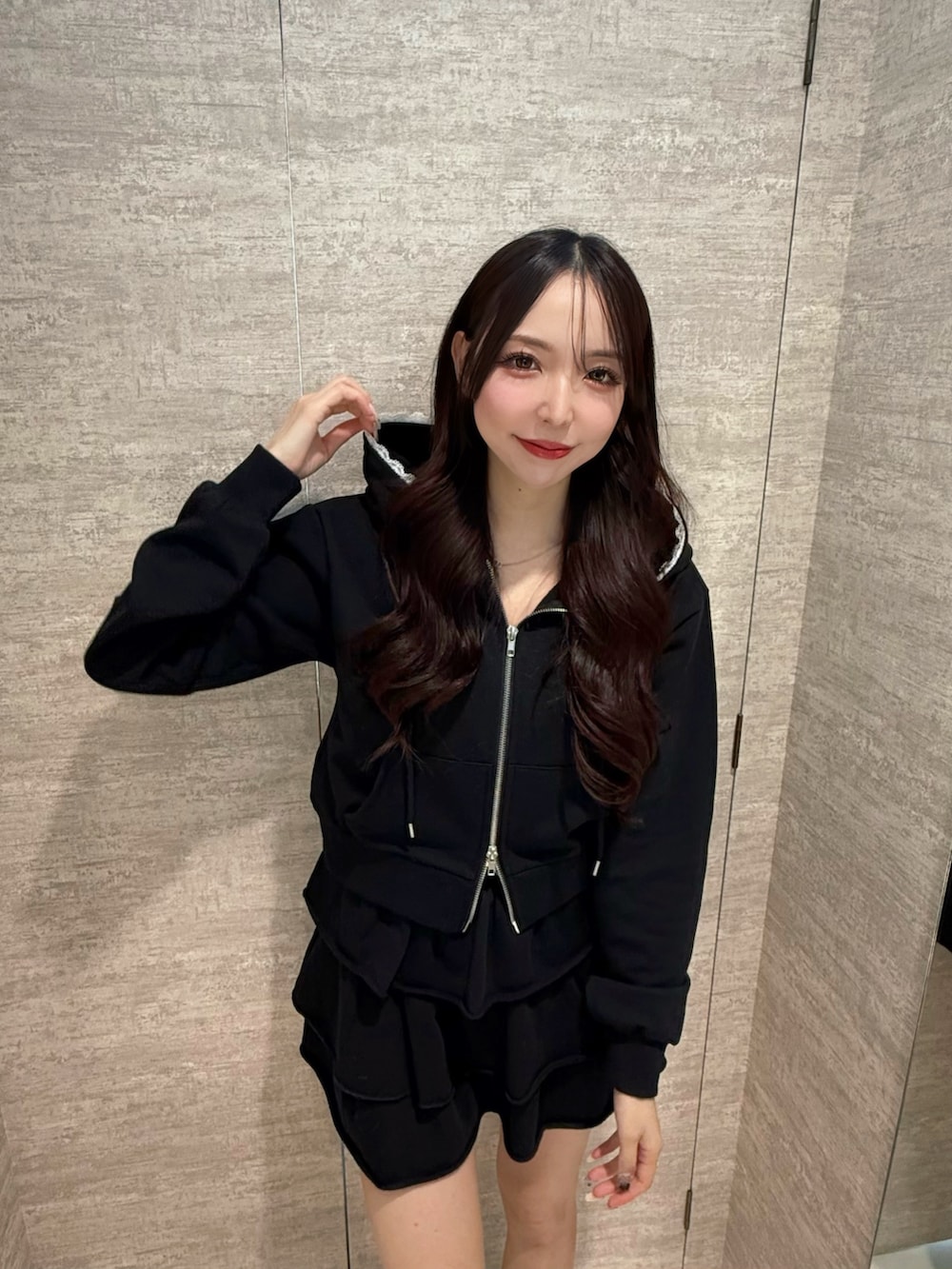 ブラック系のブーツ、ブラック系のスカート、ブラック系のパーカーを着用したレディースの秋コーディネートの3枚目の写真