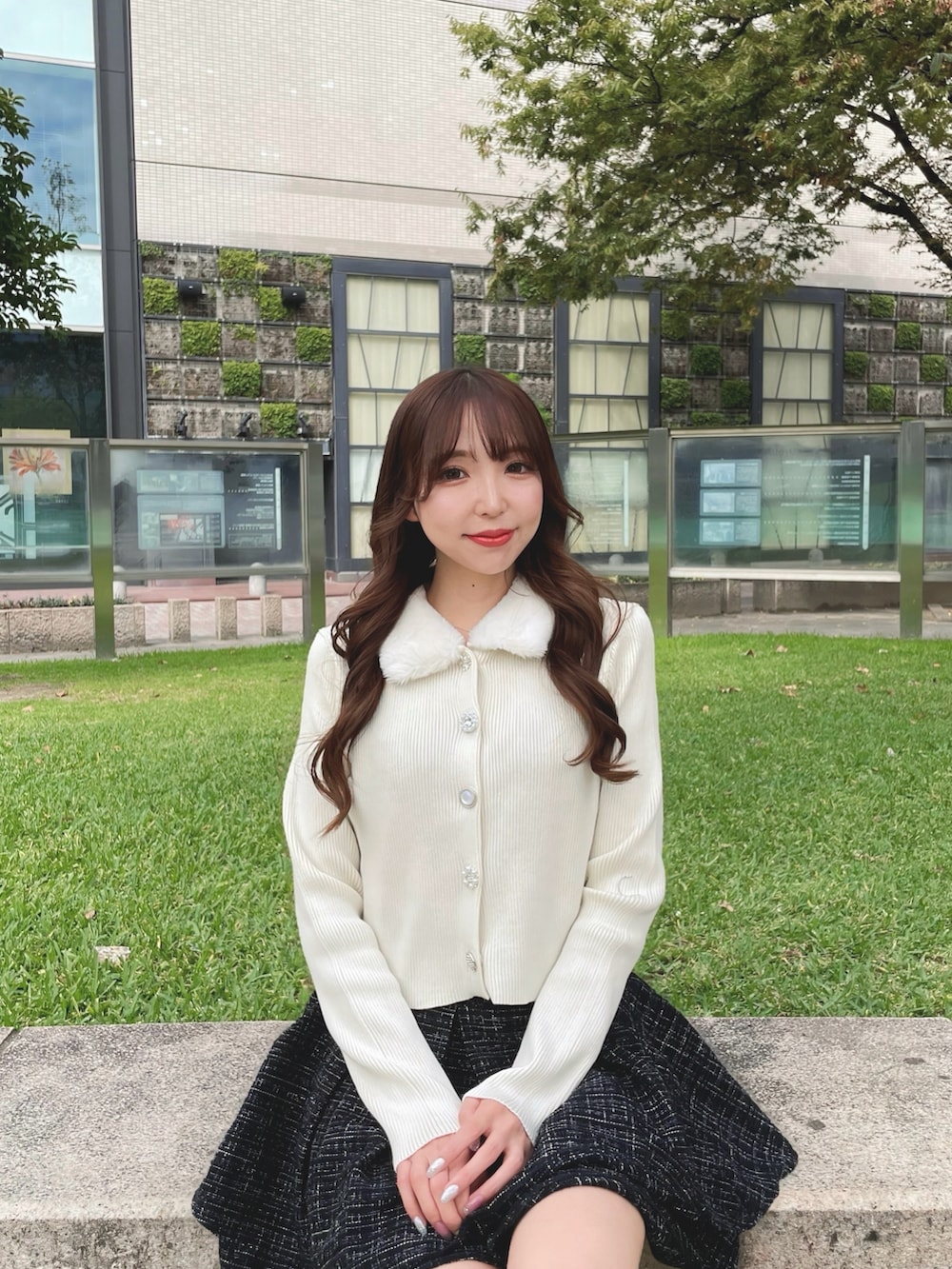 ホワイト系のカーディガン/ボレロ、ブラック系のスカートを着用したレディースの秋コーディネートの3枚目の写真