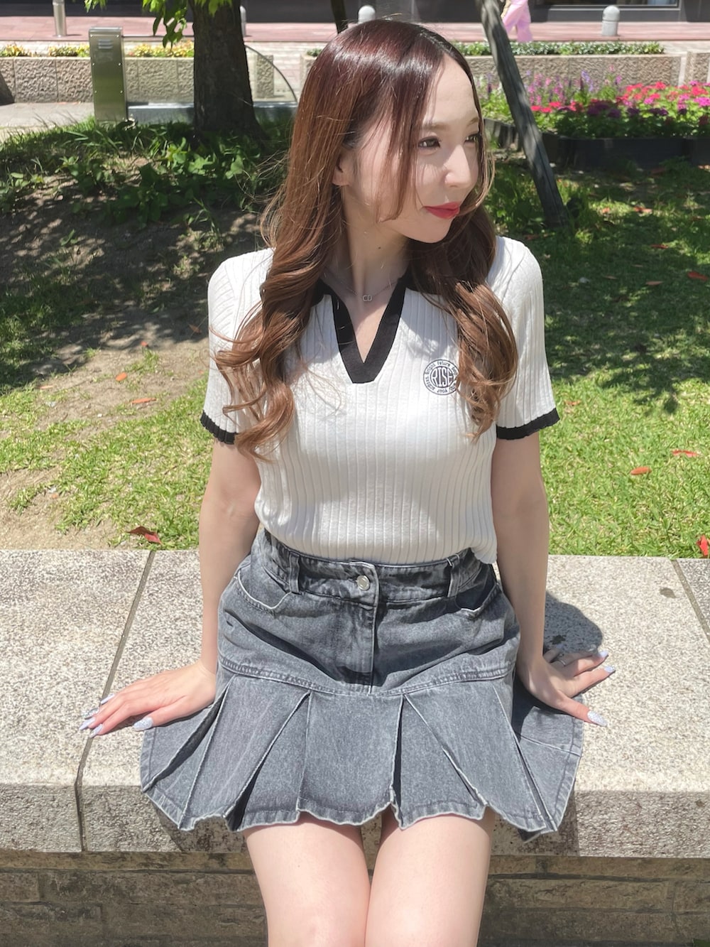 ホワイト系のニット/セーター、グレー系のデニムスカート、ブラック系のサンダルを着用したレディースの夏コーディネートの2枚目の写真