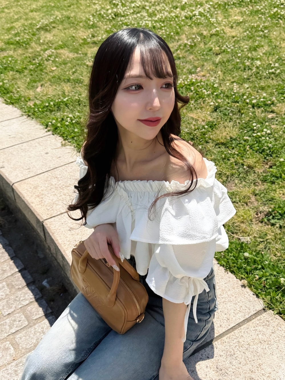 ホワイト系のシャツ/ブラウス、ブルー系のデニムパンツ、イエロー系のハンドバッグを着用したレディースの春コーディネートの3枚目の写真