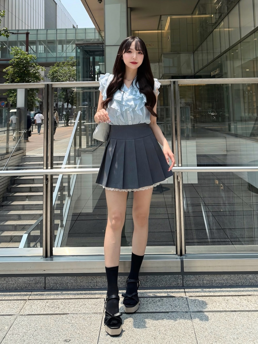 ブルー系のシャツ/ブラウス、グレー系のスカート、ブラック系のサンダルを着用したレディースの夏コーディネートの2枚目の写真