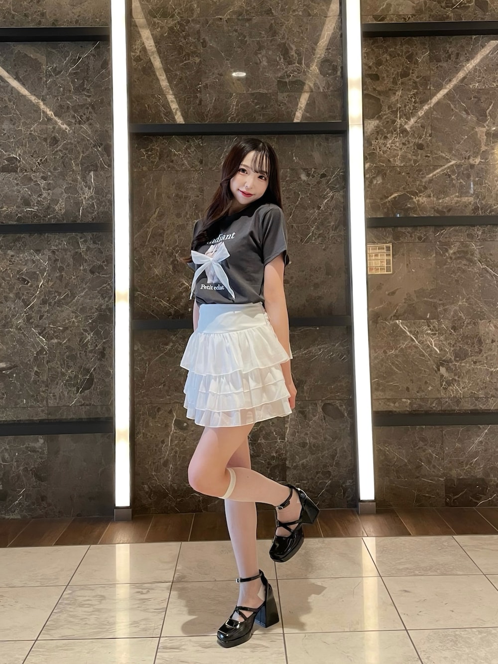 グレー系のTシャツ/カットソー、ホワイト系のスカートを着用したレディースの春コーディネートの2枚目の写真