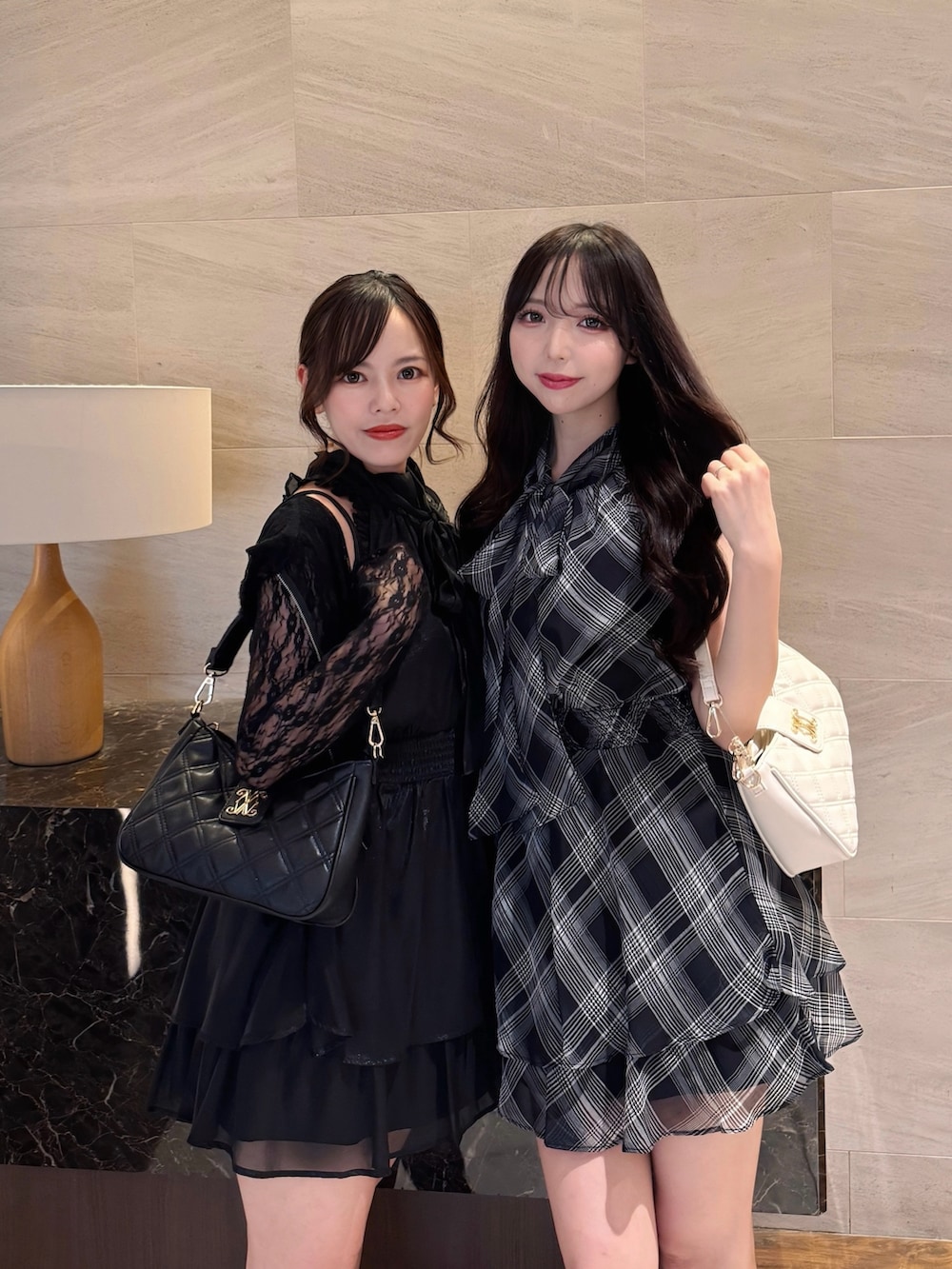 ブラック系のワンピース、ホワイト系のショルダーバッグ、ブラック系のサンダルを着用したレディースの夏コーディネートの2枚目の写真